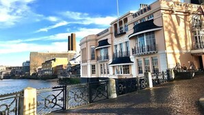 A waterfront building with a prominent entrance and a flagpole.