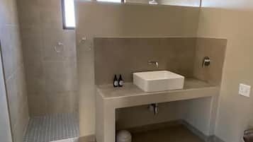 Un bagno con doccia, lavandino e WC.