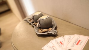 Two ceramic teapots on a table with a tray of nuts and three 'CINEMA' cards. - Cinemovie Guesthouse (Rome)
