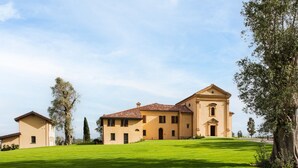 A large, two-story building with a symmetrical facade, a central entrance, and a well-maintained lawn in front.