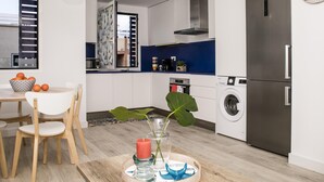 Una cocina moderna con comedor, electrodomésticos de acero inoxidable y un centro de mesa decorativo con planta.