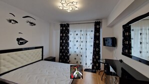 Ein Schlafzimmer mit Bett, Fernseher und Spiegel.