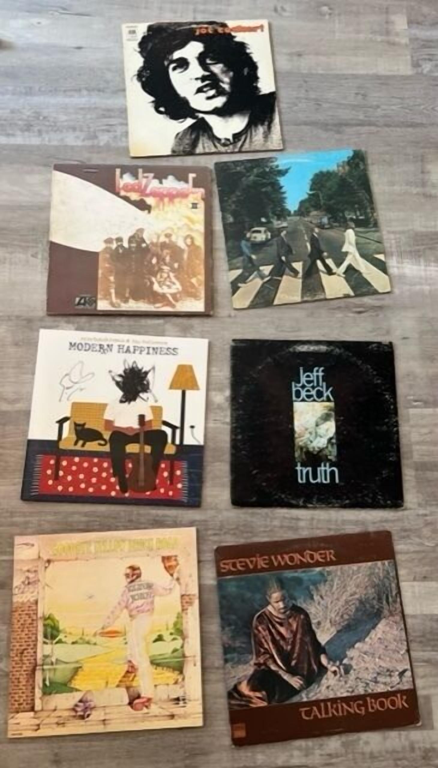 A collection of vintage album covers laid out on a wooden surface.