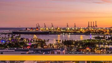 A coastal industrial area with cranes and illuminated structures at dusk.
