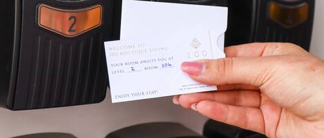 A hand holding a welcome card for a boutique hotel, indicating a room number 2 and level 2.