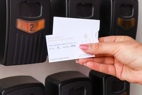A hand holding a welcome card for a boutique hotel, indicating a room number 2 and level 2.