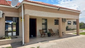 Un edificio con parabola, ingresso coperto e posti a sedere all'aperto.