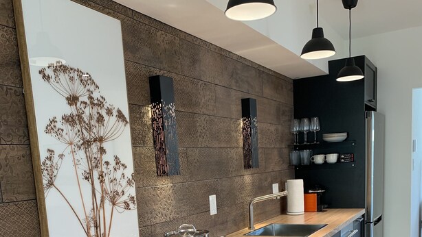Una cocina moderna con encimera de madera, electrodomésticos de acero inoxidable y armarios negros.
