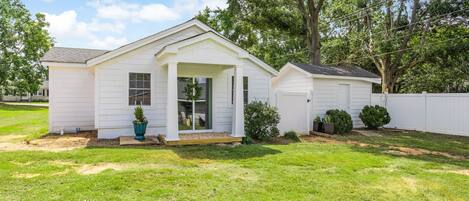 A single-story house with a front porch, a garage, and a well-maintained lawn.