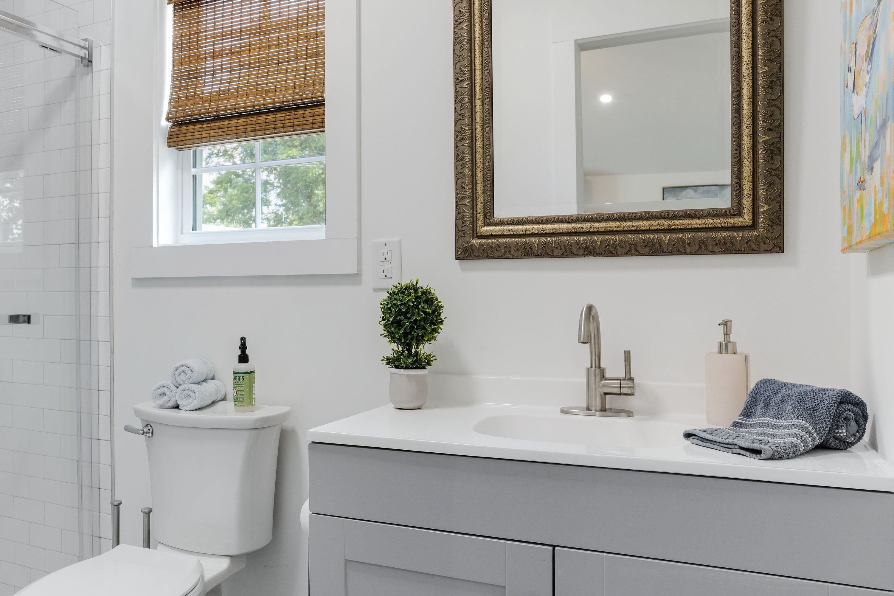Un baño moderno con inodoro, lavamanos y espejo.