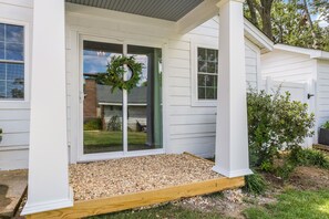 A house with a front porch, a wooden deck, and a wreath on the door. -  Adorable Upscale cottage in Downtown Fountain Inn.  (Fountain Inn)