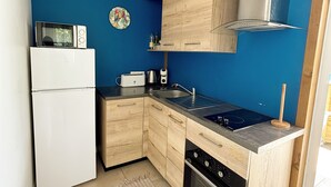 A compact kitchen with a white refrigerator, a microwave, a sink, and a stove. - Bunghello Village - Private Pool & Spa | Évasion Tropicale (Trois-Rivières)