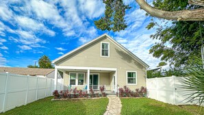 A single-story house with a front porch, a covered entryway, and a small front yard with a pathway leading to the door. - Pool & Hot Tub Home (St. Augustine)