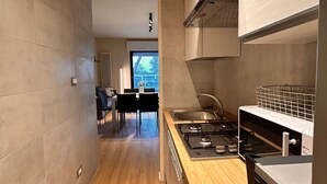 Uma cozinha moderna com fogão a gás, pia e bancada de madeira.