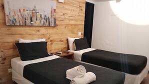 A hotel room with two beds, wooden paneling on the walls, and a painting above the beds. - Santa Maria Express (Santiago)