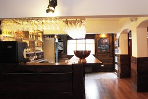 A bar area with wooden furniture, a large copper bowl centerpiece, and a wine rack. - Santa Maria Express (Santiago)