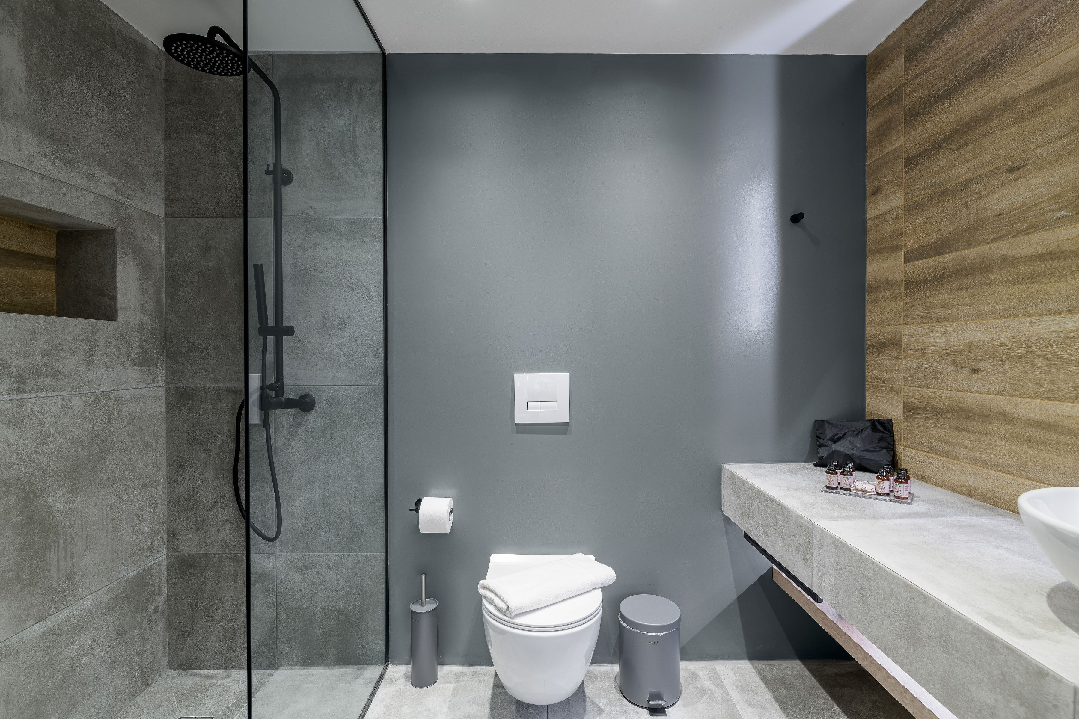 A modern bathroom with a shower, toilet, and sink.
