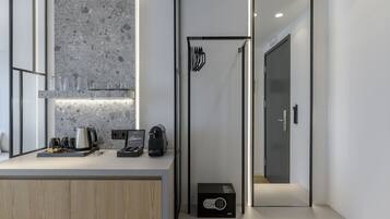 A modern kitchen with a granite countertop, a coffee machine, and a black box.