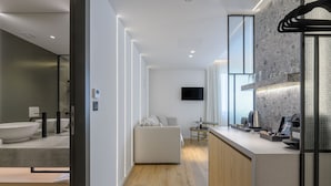 A modern kitchen with a built-in oven, a dining area with a small table, and a large window. - Acropolis Magenta (Athens)