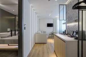A modern kitchen with a built-in oven, a dining area with a small table, and a large window.