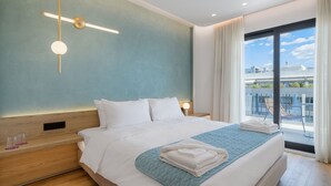 A modern hotel room with a large bed, a view of the city, and a balcony with outdoor seating. - Acropolis Magenta (Athens)
