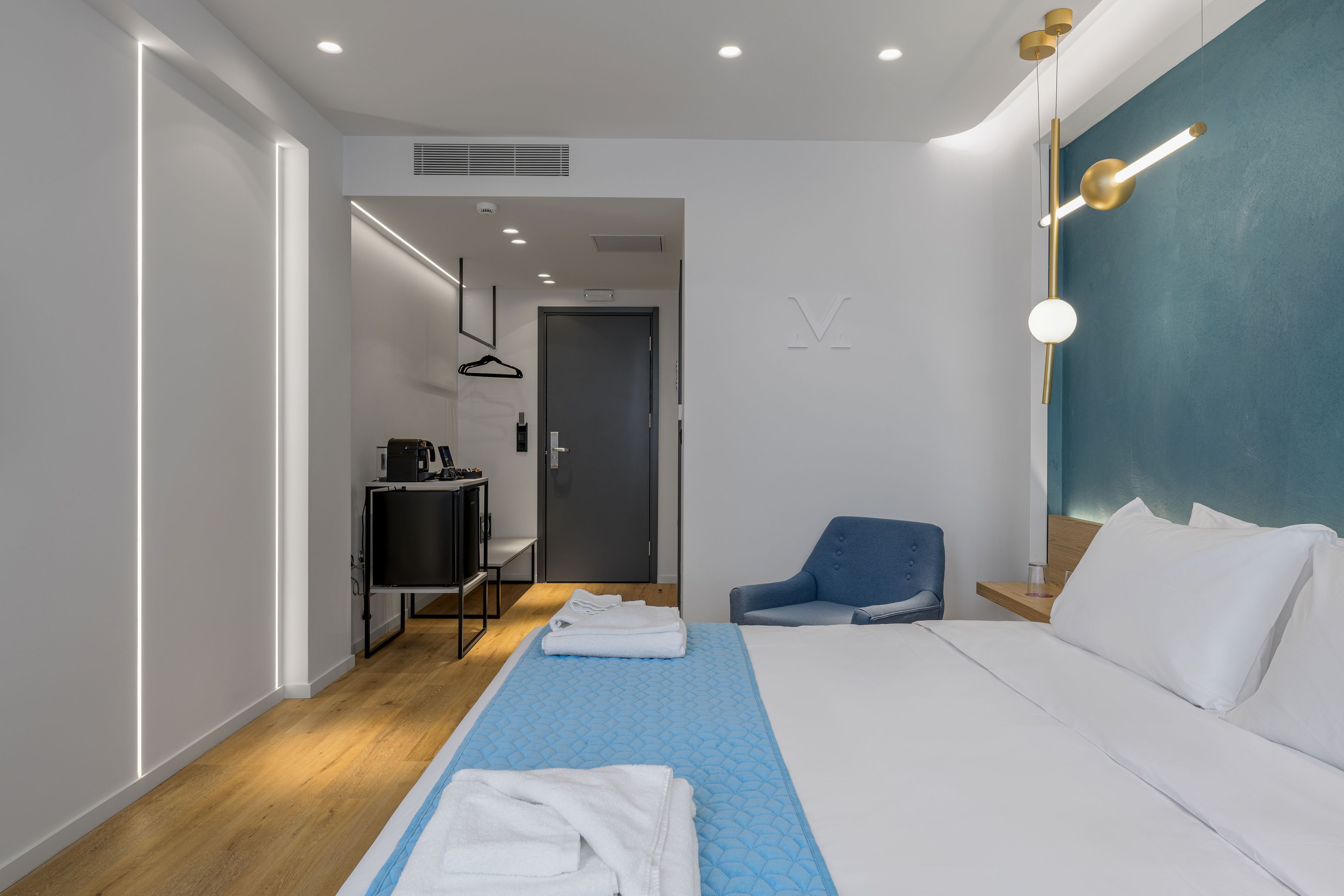 Una habitación de hotel moderna con una cama grande, un escritorio, una silla y un televisor.