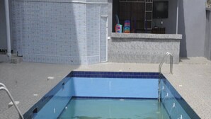 A rectangular swimming pool with a blue interior and a tiled border. - Fisher Suites and Apartment (Abuja)