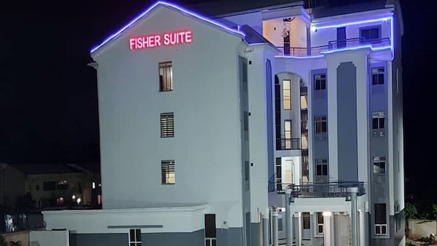 A hotel named 'Fisher Suite' with a modern design, featuring a prominent entrance and a well-lit facade. - Fisher Suites and Apartment (Abuja)