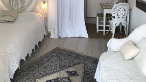 Une chambre à coucher avec un lit, une chaise, un bureau et une porte.