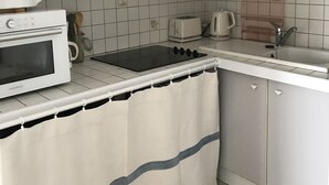 Une cuisine compacte équipée d’une cuisinière, d’un four à micro-ondes et d’un grille-pain.