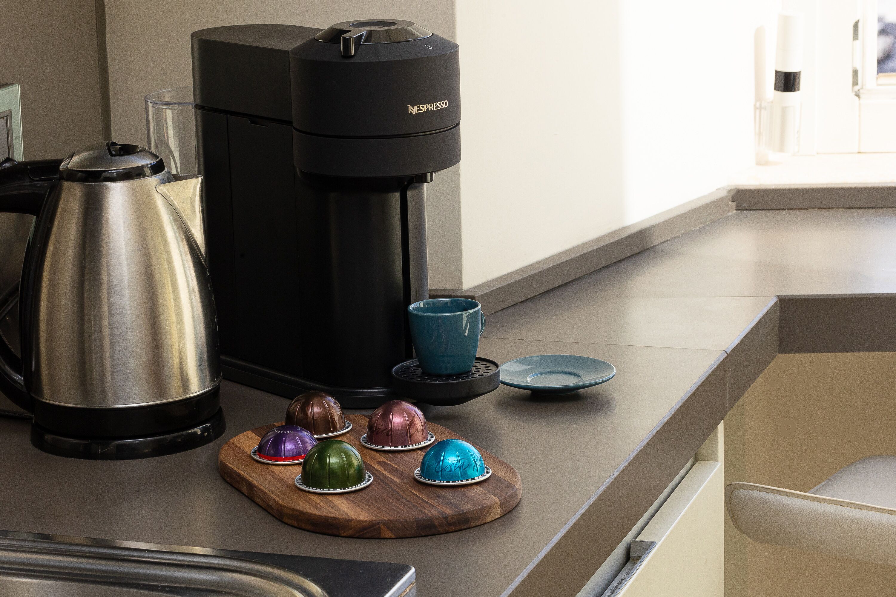 A kitchen counter with a coffee maker, a kettle, and decorative chocolate eggs.