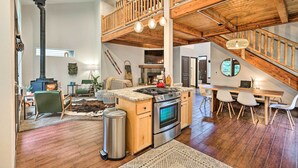 Un loft spacieux comprenant une cuisine, un coin repas et un escalier en bois.