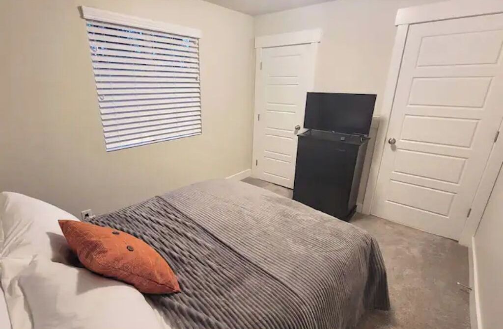 Une chambre à coucher avec un lit, une télévision et une armoire.