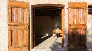 Un edificio rústico de piedra con puertas de madera y suelo adoquinado.