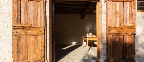 A rustic stone building with wooden doors and a cobblestone floor.