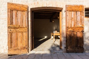 Um edifício rústico de pedra com portas de madeira e chão de pedra.