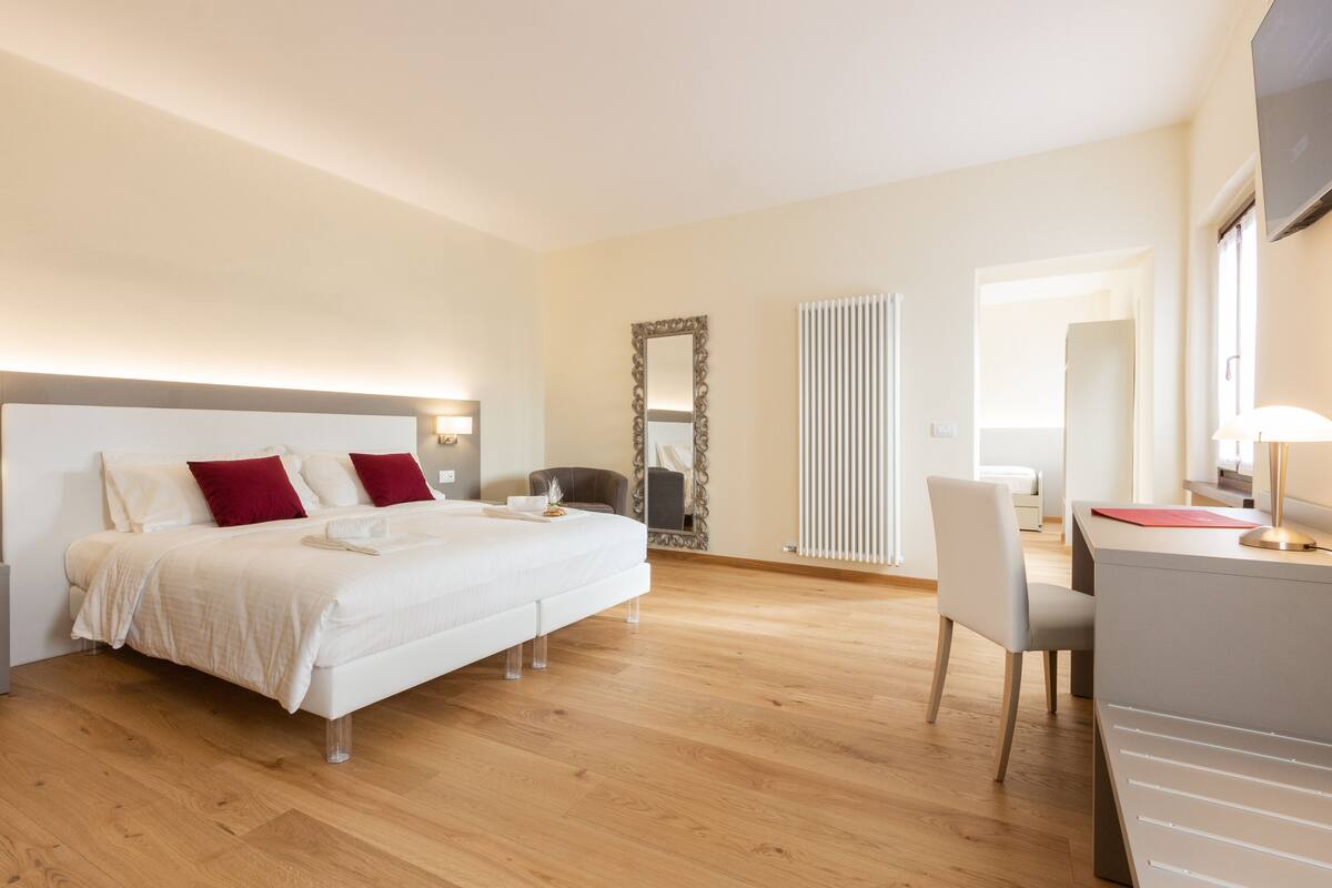 Une chambre moderne avec un grand lit, des tables de chevet, un bureau et une chaise.