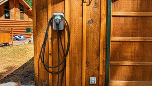 En træhytte med en synlig stikkontakt og et kabel tilsluttet.