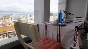 A balcony with a table set for two, overlooking a cityscape. - Charming Colonial Flat in historic building (Castle Road)