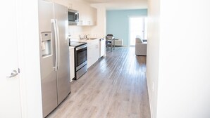 Una cocina moderna con electrodomésticos de acero inoxidable, dispensador de agua y una zona de comedor con mesa y sillas.