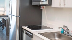 Una cocina moderna con electrodomésticos de acero inoxidable, microondas integrado y lavavajillas.