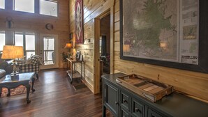 A wooden interior with a large map, a checkered sofa, and a lamp. - Starway to Heaven Cabin at Red River Gorge  - Hot Tub - Great View (Frenchburg)
