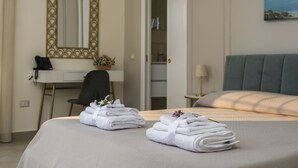Et hotelværelse med en seng, et skrivebord med telefon, et spejl og en dør til et badeværelse.