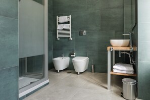 A modern bathroom with a glass shower enclosure, a white sink with a vessel basin, and a toilet. - Residenza d'epoca Chiostro San Francesco (Naples)