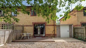 A brick house with a patio, a sliding glass door, and a white door.