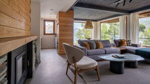 Una sala de estar moderna con chimenea, un juego de sofás y un comedor.