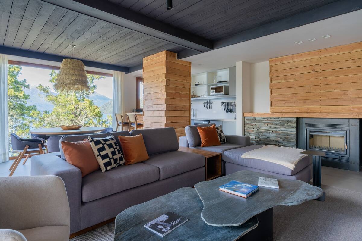 A modern living room with a sofa, coffee table, and fireplace.