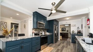 A modern kitchen with dark blue cabinets, a stainless steel refrigerator, and a marble countertop. - Seasonal Heated pool in the Bluegrass (Union)
