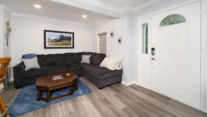 A living room with a dark grey sectional sofa, a wooden coffee table, and a blue rug. - Seasonal Heated pool in the Bluegrass (Union)