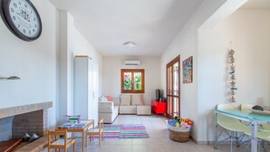 Uma sala de estar ampla com lareira, área de jantar e cozinha.